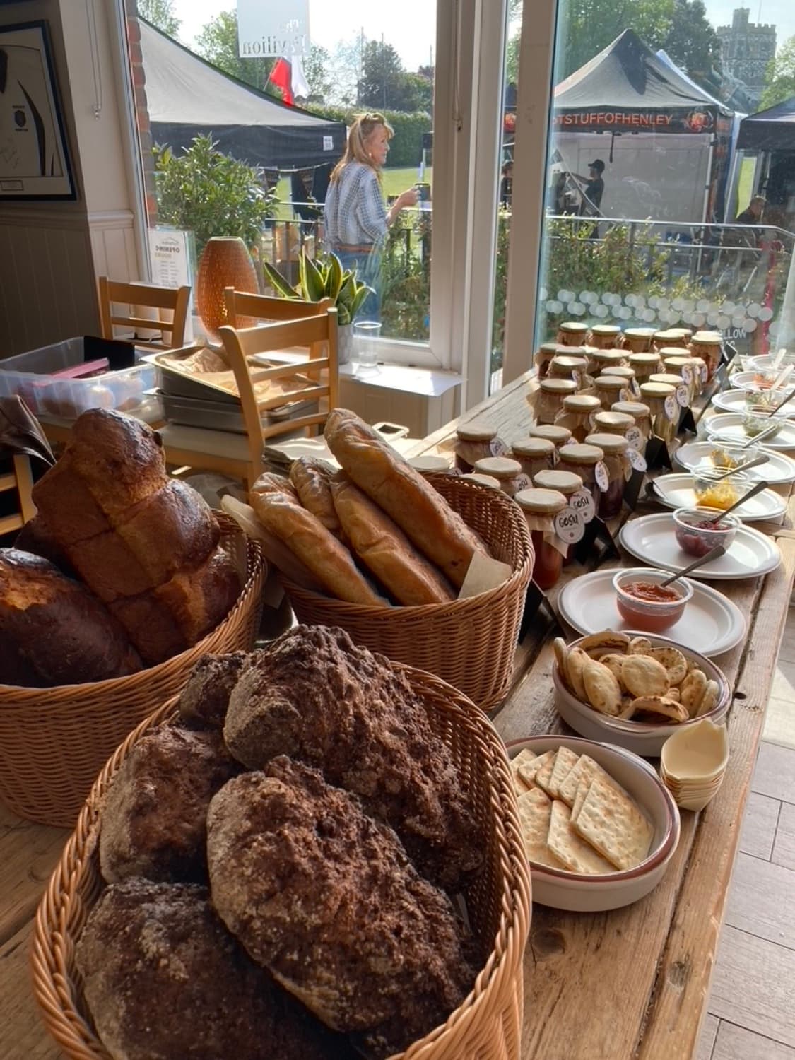 Patrick and Julie's market table with baskets of bread and rows of Gosu Pantry jars