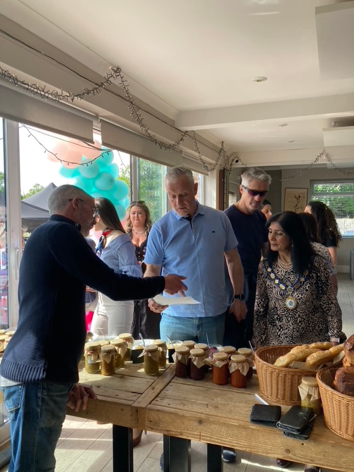 Patrick presenting Gosu Pantry jars and breads to visitors at a market stall